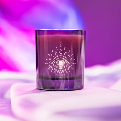 Purple candle jar with e mystical eye engraved on it.
