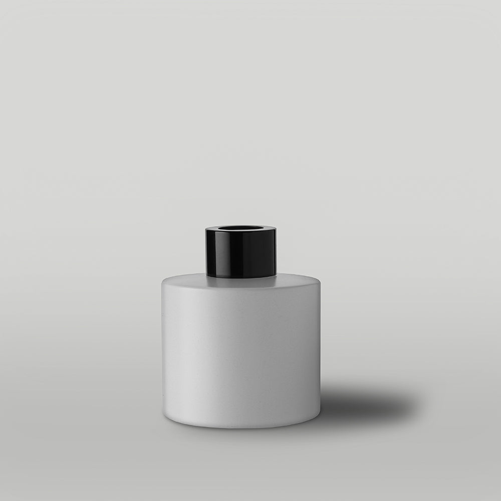 White diffuser bottle with black lid on a light gray background