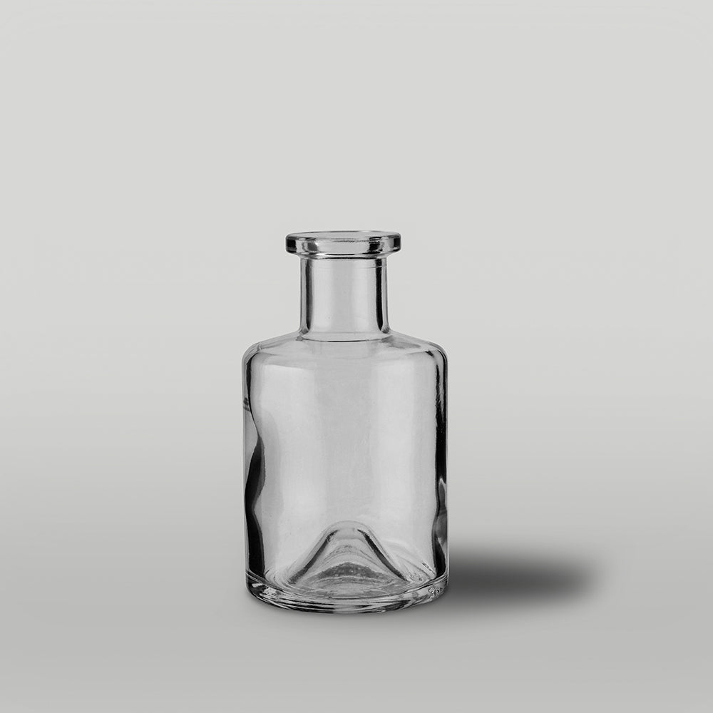 Clear glass diffuser bottle on a light gray background