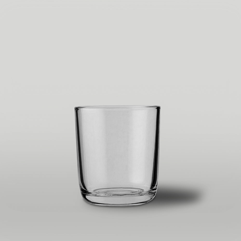 Clear glass candle jar on a gray background