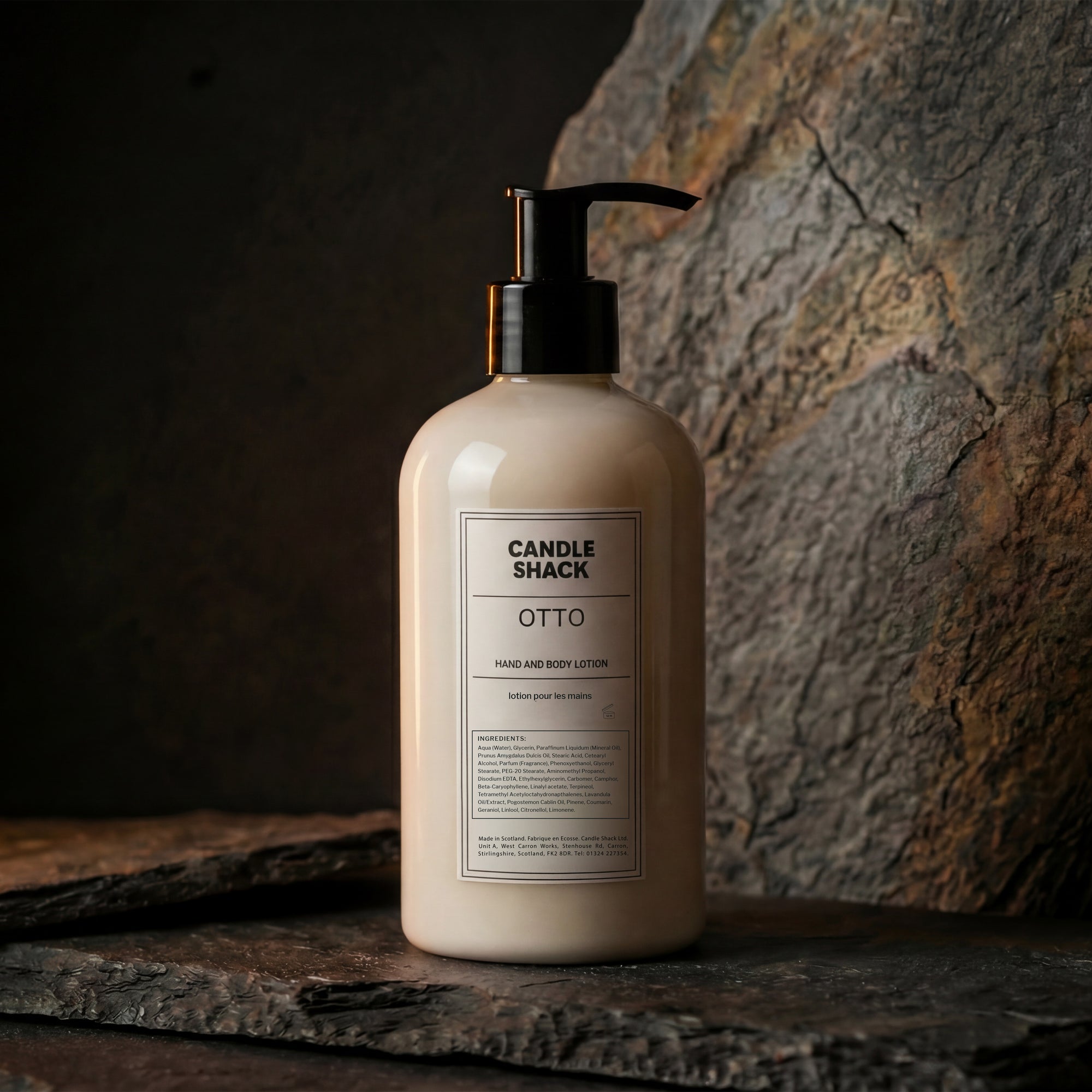 Lotion bottle labeled 'Candle Shack Luna' on a stone surface with a dark background