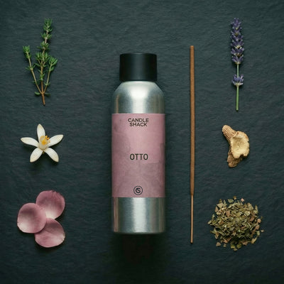 Candle Shack Otto diffuser bottle with lavender, thyme, and other botanicals on a dark surface