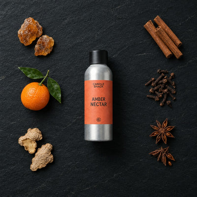 Amber Nectar fragrance oil - Candle Shack aluminium bottle with dried botanicals on a dark slate background
