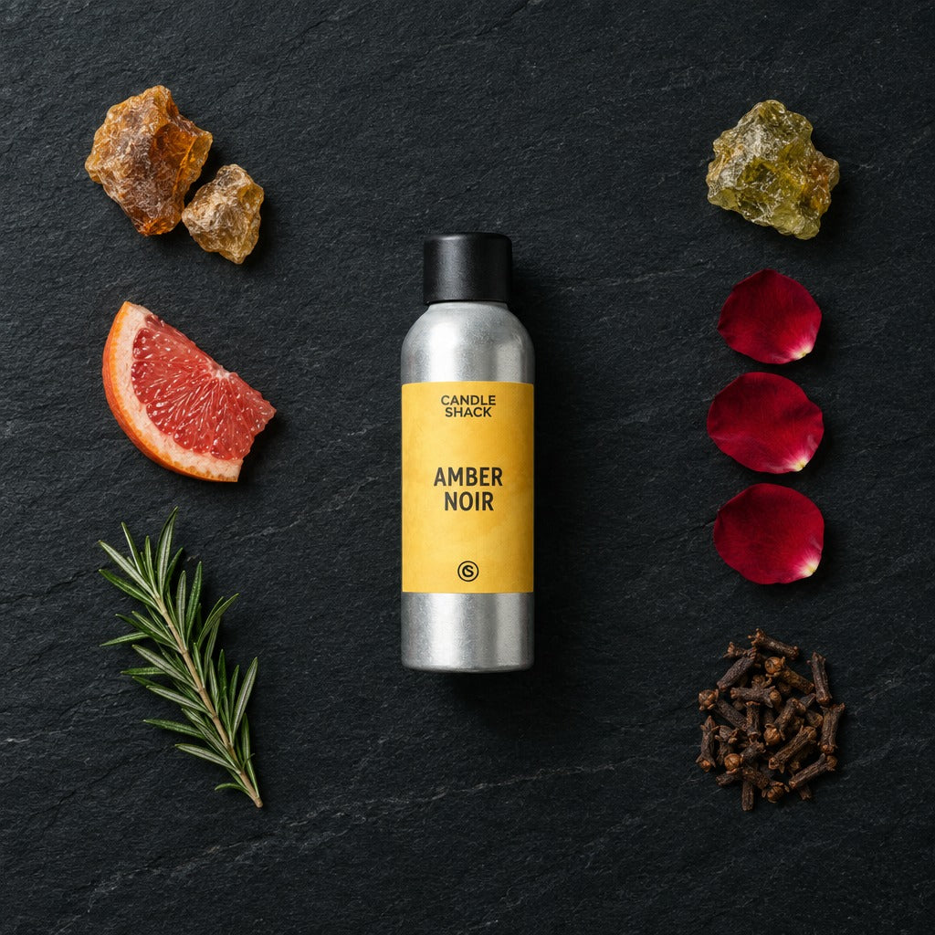 Amber Noir fragrance oil - Candle Shack aluminium bottle with dried botanicals on a dark slate background