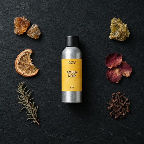 Amber Noir fragrance oil - Candle Shack aluminium bottle with dried botanicals on a dark slate background