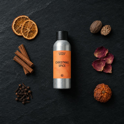 Christmas Spice fragrance oil - Candle Shack aluminium bottle with dried botanicals on a dark slate background