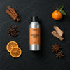 Christmas Wish fragrance oil - Candle Shack aluminium bottle with dried botanicals on a dark slate background