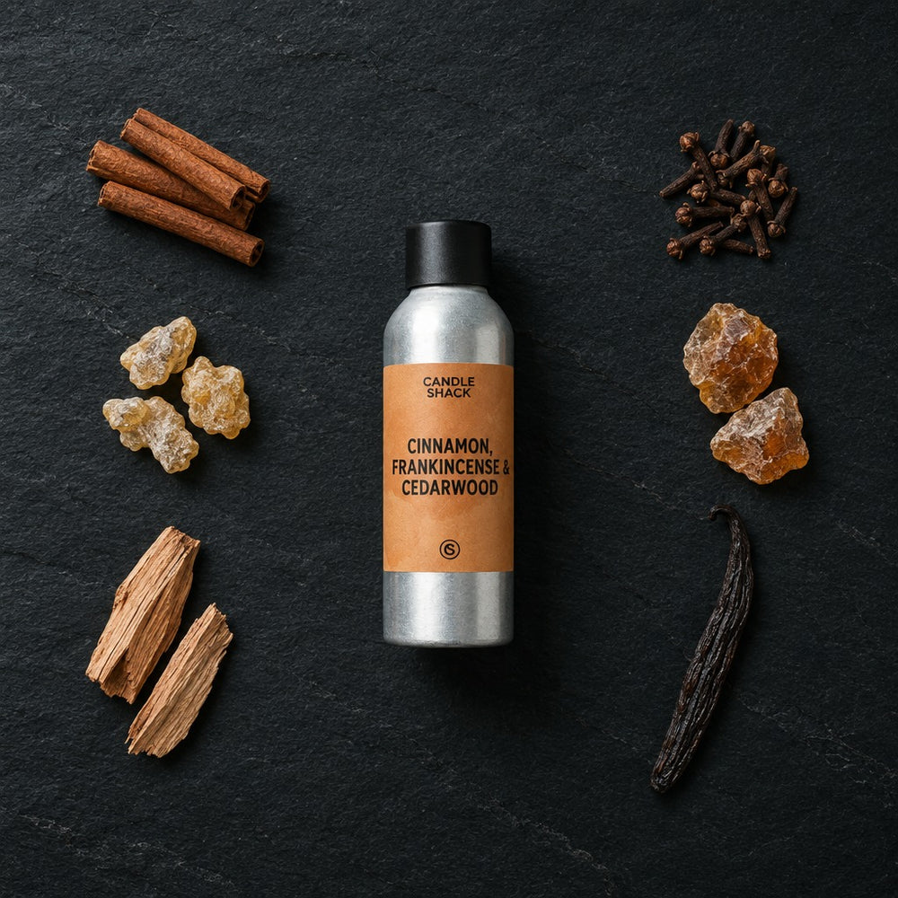 Cinnamon, Frankincense & Cedarwood fragrance oil - Candle Shack aluminium bottle with dried botanicals on a dark slate background