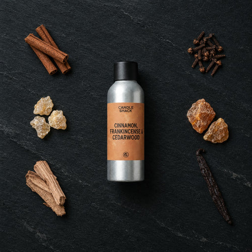 Cinnamon, Frankincense & Cedarwood fragrance oil - Candle Shack aluminium bottle with dried botanicals on a dark slate background
