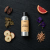 Cocoa & Patchouli fragrance oil - Candle Shack aluminium bottle with dried botanicals on a dark slate background