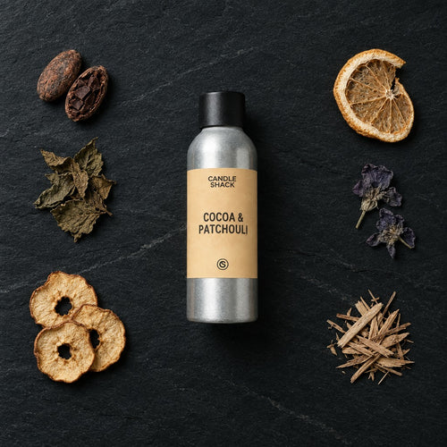 Cocoa & Patchouli fragrance oil - Candle Shack aluminium bottle with dried botanicals on a dark slate background