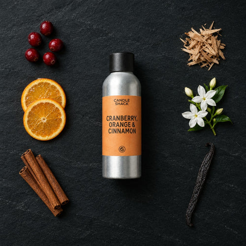 Cranberry, Orange and Cinnamon fragrance oil - Candle Shack aluminium bottle with dried botanicals on a dark slate background