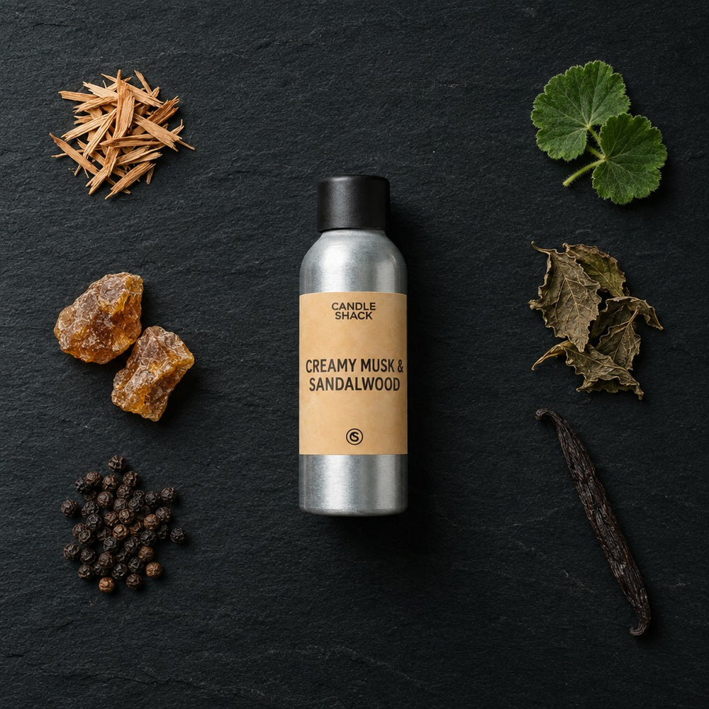 Creamy Musk and Sandalwood fragrance oil - Candle Shack aluminium bottle with dried botanicals on a dark slate background