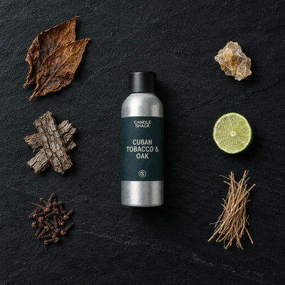 Cuban Tobacco & Oak fragrance oil - Candle Shack aluminium bottle with dried botanicals on a dark slate background