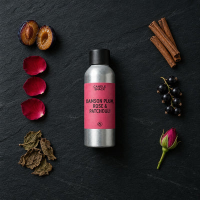 Damson Plum, Rose & Patchouli fragrance oil - Candle Shack aluminium bottle with dried botanicals on a dark slate background