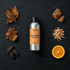 Dark Honey & Tobacco fragrance oil - Candle Shack aluminium bottle with dried botanicals on a dark slate background