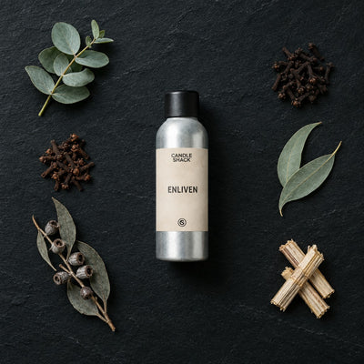 Enliven Natural Oil fragrance oil - Candle Shack aluminium bottle with dried botanicals on a dark slate background