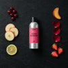 Festive Cranberry fragrance oil - Candle Shack aluminium bottle with dried botanicals on a dark slate background