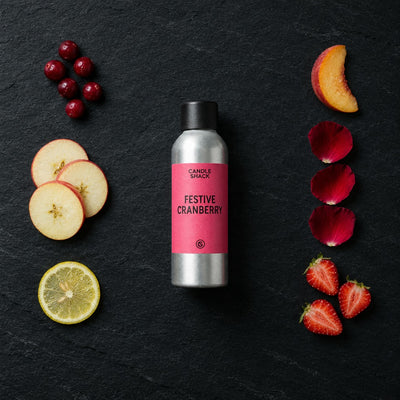 Festive Cranberry fragrance oil - Candle Shack aluminium bottle with dried botanicals on a dark slate background