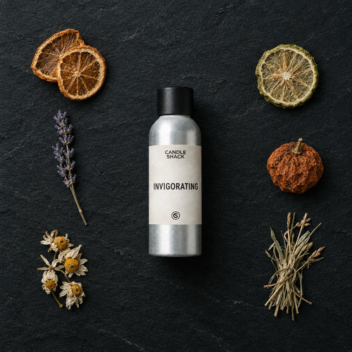 Invigorating Natural Oil fragrance oil - Candle Shack aluminium bottle with dried botanicals on a dark slate background