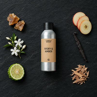 Ivory & Amber fragrance oil - Candle Shack aluminium bottle with dried botanicals on a dark slate background