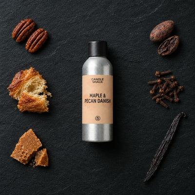 Maple & Pecan Danish fragrance oil - Candle Shack aluminium bottle with dried botanicals on a dark slate background