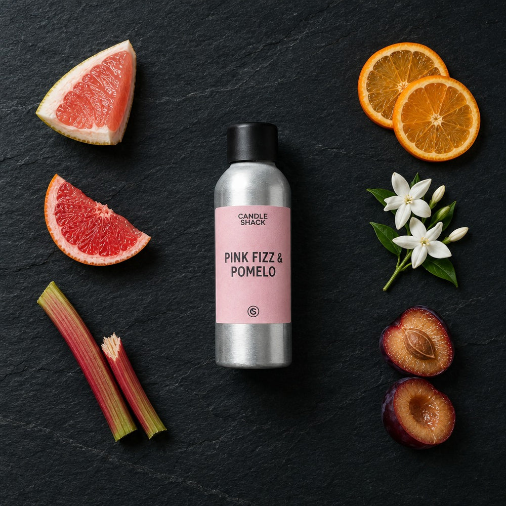 Pink Fizz & Pomelo fragrance oil - Candle Shack aluminium bottle with dried botanicals on a dark slate background