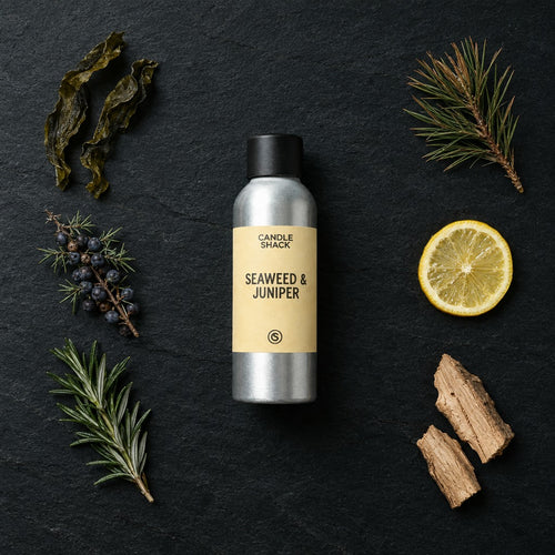 Seaweed and Juniper fragrance oil - Candle Shack aluminium bottle with dried botanicals on a dark slate background