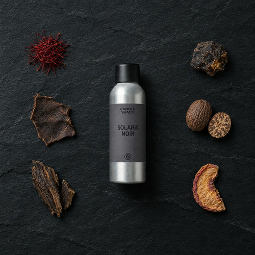 Solaris Noir fragrance oil - Candle Shack aluminium bottle with dried botanicals on a dark slate background
