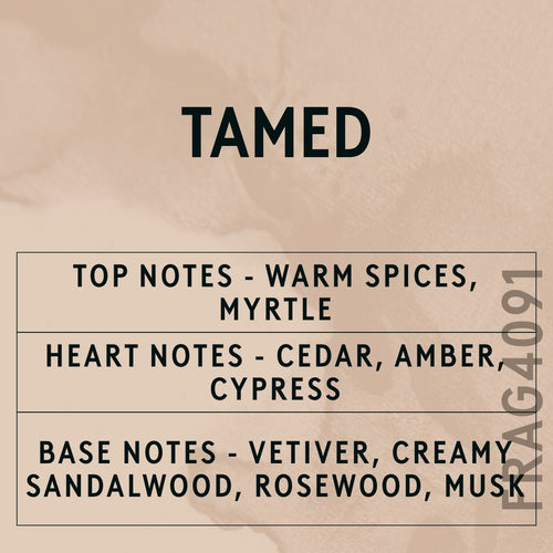 Tamed fragrance oil - Candle Shack aluminium bottle with dried botanicals on a dark slate background
