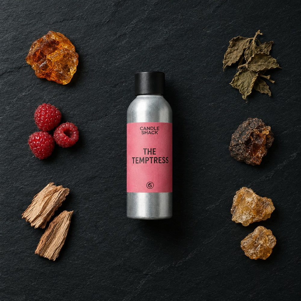 The Temptress fragrance oil - Candle Shack aluminium bottle with dried botanicals on a dark slate background