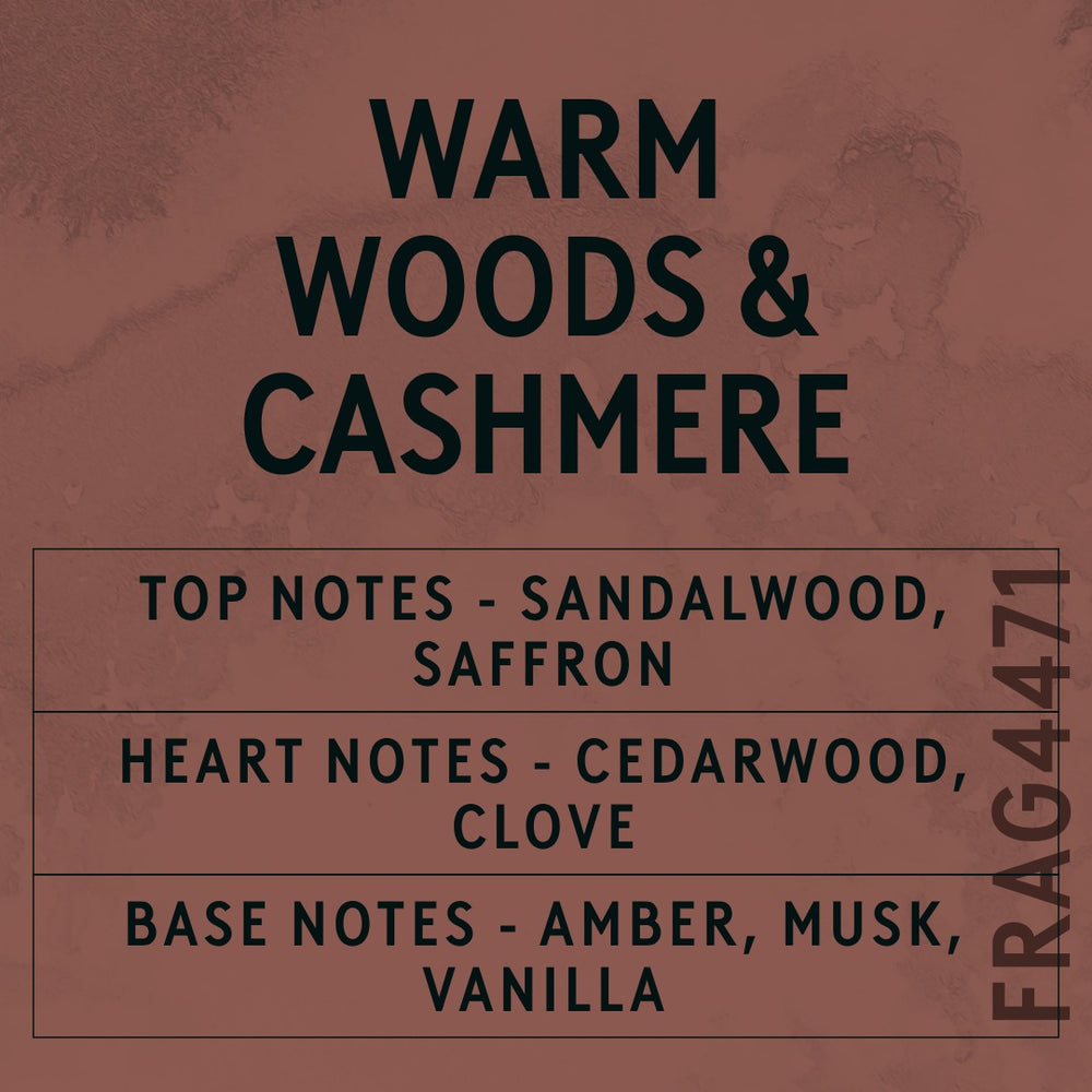 Warm Woods & Cashmere fragrance oil - Candle Shack aluminium bottle with dried botanicals on a dark slate background