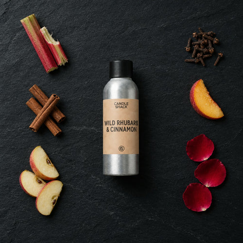 Wild Rhubarb & Cinnamon fragrance oil - Candle Shack aluminium bottle with dried botanicals on a dark slate background