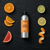 Zesty Orange fragrance oil - Candle Shack aluminium bottle with dried botanicals on a dark slate background