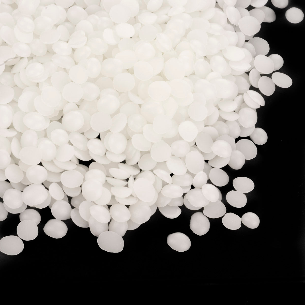 White wax pellets for candle making piled on a black background. Golden Wax 464 (now made in Europe) 