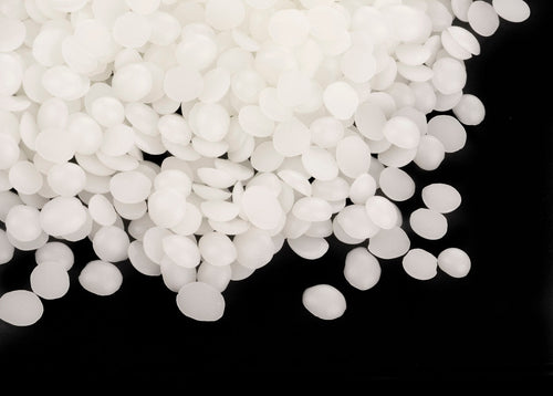 White wax pellets for candle making piled on a black background. Golden Wax 464 (now made in Europe) 